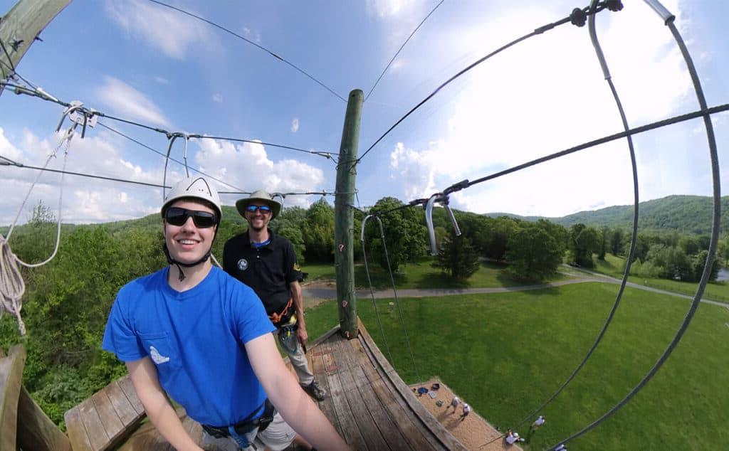 student standing at the top of the climbing tower